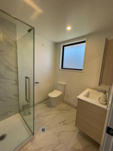 Un baño con ducha, inodoro y lavabo. en Well-furnished Auckland Stunner, en Auckland