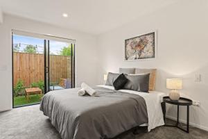 a bedroom with a large bed and a sliding glass door at Perfect For You and Your Family in Auckland
