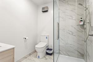 a bathroom with a toilet and a glass shower at Perfect For You and Your Family in Auckland