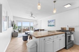 Una cocina con gabinetes blancos y encimera. en Private beach toes on the Sand Waterworld, en Dana Point