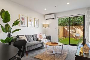 una sala de estar con un sofá y una mesa en Charming 2 Bed Family Home, en Auckland