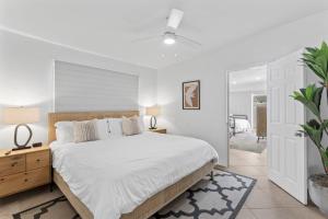 Un dormitorio con una cama grande con sábanas blancas. en Private beach toes on the Sand Waterworld, en Dana Point