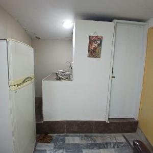 a kitchen with a white refrigerator and a sink at Elegant Single Bedroom Islamabad in Islamabad