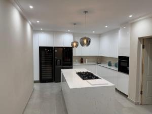 a large white kitchen with a stove top island at Villa 374 Vaal De Grace in Grooteiland