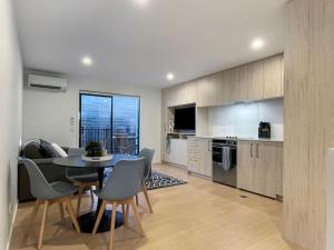 a kitchen and dining room with a table and chairs at Light and Central CBD Stay in Christchurch +4 photos