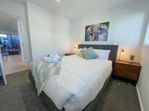 a bedroom with a large bed with a stuffed animal on it at Light and Central CBD Stay in Christchurch