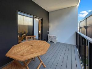 a room with a wooden table on a balcony at Light and Central CBD Stay in Christchurch