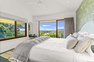 ein weißes Schlafzimmer mit großem Bett und Fenstern in der Unterkunft Cape Vue - Vue 5 Byron Bay in Ewingsdale