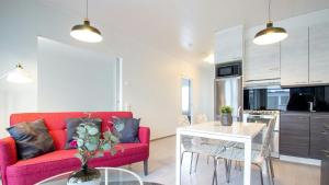 a living room with a red couch and a table at Convenient Apartment for 4 with Sauna in Porvoo