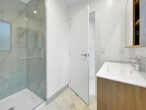 基督城CBD Gem - Studio on Allen Street的带水槽和淋浴的白色浴室