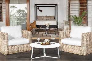 a porch with wicker chairs and a table and a bed at Cape Vue - Vue 2 Byron Bay in Ewingsdale
