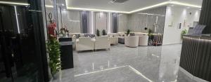 a waiting room with white chairs and tables in it at النخبة للشقق المخدومة in Hafr Al-Batin
