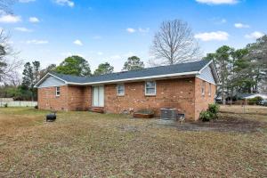 a brick house with a dog in the yard at Its The Blue Hacienda in Hope Mills