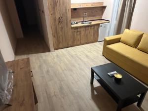 a living room with a yellow couch and a table at NIKA The architect DIAMOND OF GEVGELIA in Gevgelija