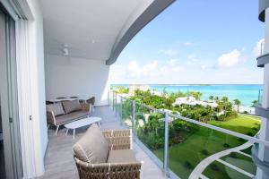 a balcony with chairs and a view of the ocean at 4 Bedroom Cable Beach Condo with Balcony in Nassau