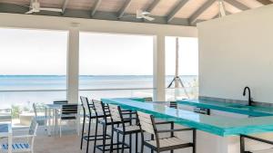 a kitchen with a blue counter and chairs and the ocean at 4 Bedroom Cable Beach Condo with Balcony in Nassau