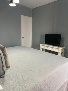 a bedroom with a bed and a desk with a television at Ayari Bed & Breakfast in Guatemala +8 photos