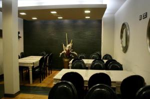 una sala de conferencias con mesas y sillas y una pared negra en Hotel Viento del Norte, en Porto de Espasante