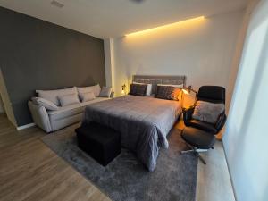 a bedroom with a bed and a couch at Suítes Lua in Castelo Branco