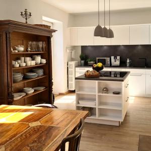 a kitchen with white cabinets and a wooden table at Haus am Bach in Fischbachau