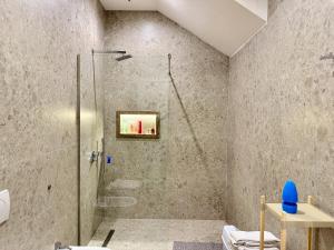 une salle de bain avec une douche avec une porte vitrée dans l'établissement Villa Ida Apartments, à Vlorë 33 autres photos