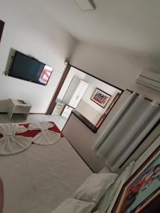 a bedroom with two beds and a flat screen tv at Hotel Villar in Penedo