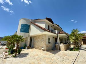 une maison blanche avec des palmiers devant dans l'établissement Villa Ida Apartments, à Vlorë