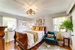 ein Schlafzimmer mit einem Bett und einem Stuhl in der Unterkunft 1 Mi to University of Cincinnati Avondale Gem! in Cincinnati
