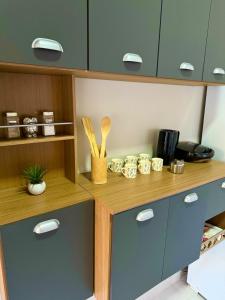 a kitchen with blue cabinets and a counter with utensils at Casa Em Goiânia - Bairro Capuava in Goiânia