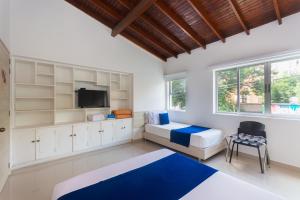 a bedroom with two beds and a flat screen tv at Hotel Suite del Parque in Medellín +27 photos