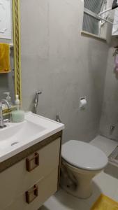 a white bathroom with a toilet and a sink at Espaço DéboraMa&Deise in Rio de Janeiro