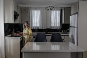 a woman standing in a kitchen with a plate of food at Villa Lotus in Sogut