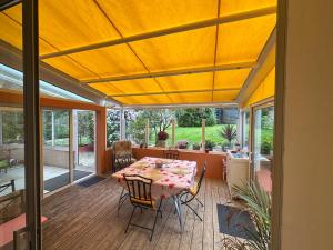 una veranda riparata con tavolo e sedie di Maison familiale à Morgat, jardin clos, à 2 minutes de la plage a Crozon