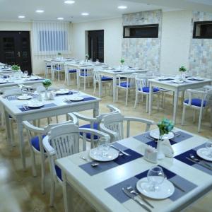 una habitación llena de mesas y sillas con platos y vasos en Panorama Hotel, en Bukhara