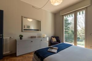 a bedroom with a bed and a mirror and a window at Cosy in the Park in Como