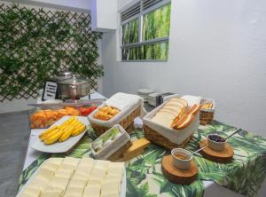 a table topped with cheese and baskets of fruit and vegetables at Hotel Suite del Parque in Medellín