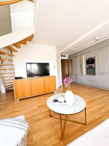 a living room with a table and a tv at Sunny Apartment Bydgoszcz in Bydgoszcz