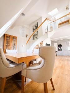 a dining room with a wooden table and chairs at Sunny Apartment Bydgoszcz in Bydgoszcz