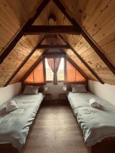 two beds in a attic room with a window at Oak House Mrežnica in Duga Resa +18 photos