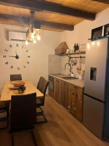 a kitchen with a table and a clock on the wall at Oak House Mrežnica in Duga Resa