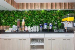a counter with a green wall with plants at Hotel Suite del Parque in Medellín