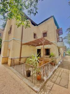 a building with potted plants in front of it at Yellow House on the Nile in Luxor