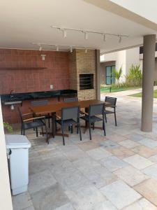 eine Terrasse mit Tisch und Stühlen und einer Backsteinmauer in der Unterkunft Malia Beach Porto Galinha By Loui in Ipojuca + 12 Fotos