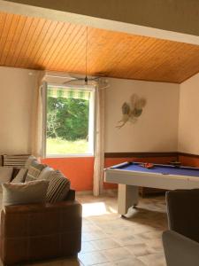 Una sala de estar con un sofá y una mesa de billar. en Maison Familiale 6 pers - Orouët, en Saint-Jean-de-Monts