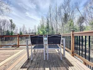 a chair sitting on top of a wooden deck at Vacances Magiques Chalet Skadi Paix Nature in Saint-Justin