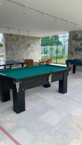 einen grünen Billardtisch in einem Zimmer mit Stühlen in der Unterkunft Malia Beach Porto Galinha By Loui in Ipojuca