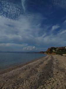 a rocky beach with a cloudy sky and the ocean at Evilion- Potidaia- Halkidiki- 100m from the sea in Nea Potidaea