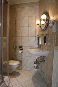 a bathroom with a sink and a toilet at Hotel Zum Bürgergarten in Stolberg