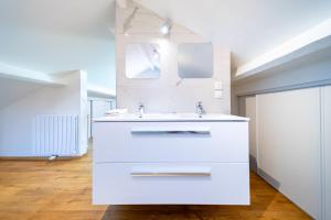 a white bathroom with a sink and a mirror at La Belle Adresse Chic, Calme & Spacieuse in Versailles +49 photos