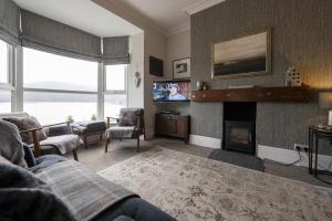 Una sala de estar con un sofá y una chimenea. en Harbour View - Flat 2, en Barmouth